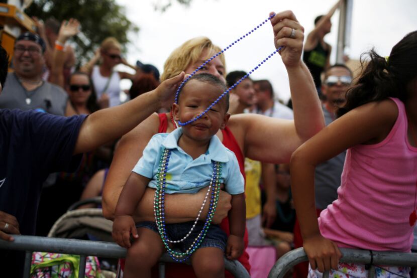 Dominic Garza, 14 months, wears beaded necklaces that his grandmothers Kristin Weatherly and...