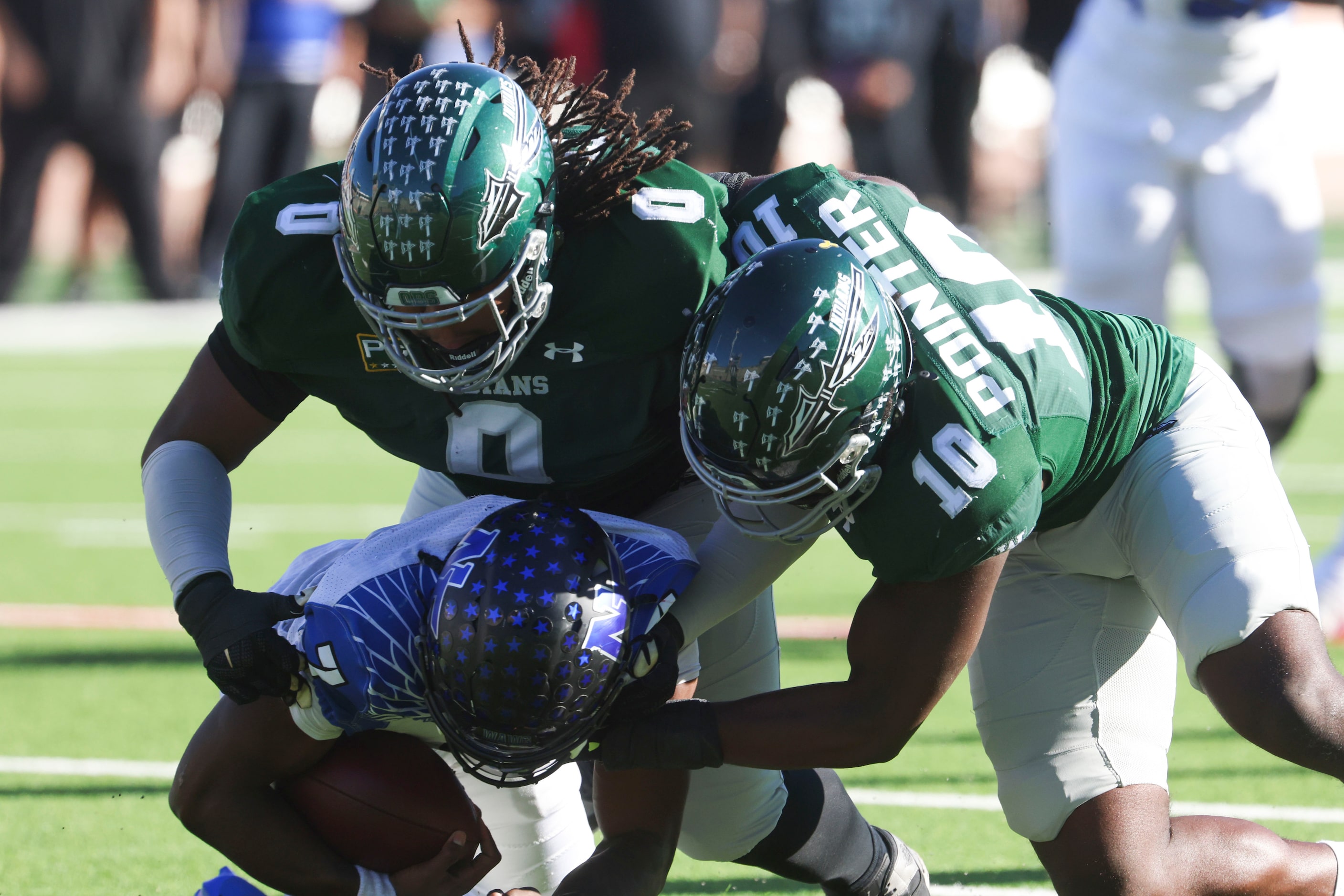 North Forney High QB Legend Bey (center) gets sacked by Waxahachie high’s Jacob Ervin (0)...