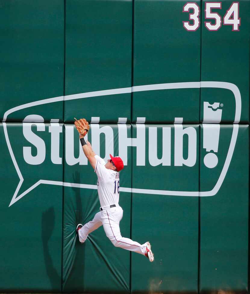 Rangers left fielder Ryan Rua leaps against the left field wall but can't get to Houston...