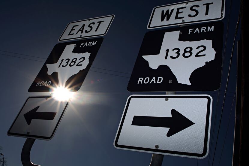 Traffic signs show the split of Farm to Road 1382 east and westbound along Beltline Road...