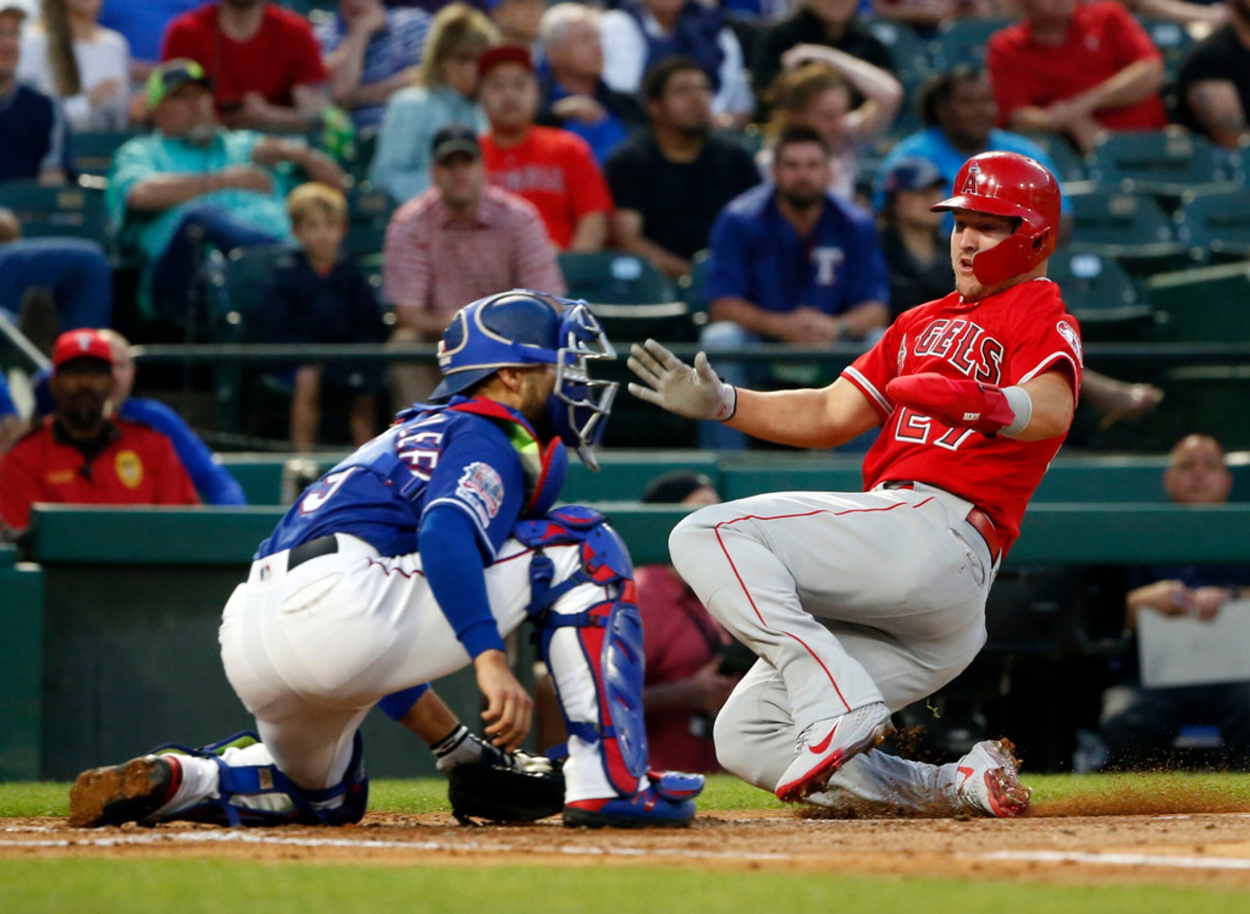 Los Angeles Angels' Mike Trout (27) scores in front of Texas Rangers catcher Isiah...