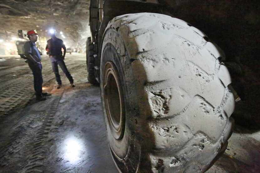 
A large front-end loader’s tires are covered with salt dust inside the Morton Salt Mine in...