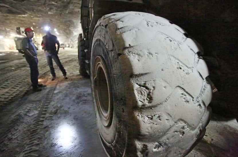 
A large front-end loader’s tires are covered with salt dust inside the Morton Salt Mine in...