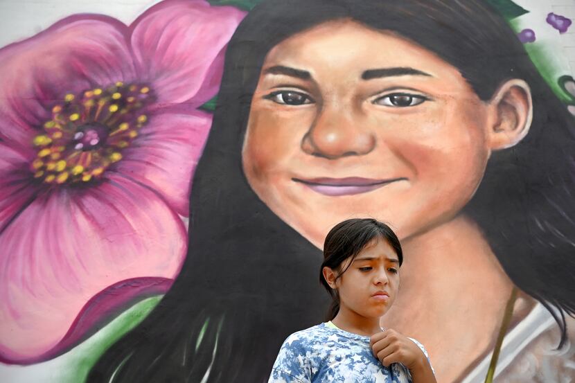 Caitlyne Gonzales, 10, pauses next to a mural of her best friend, Jackie Cazares, who was...