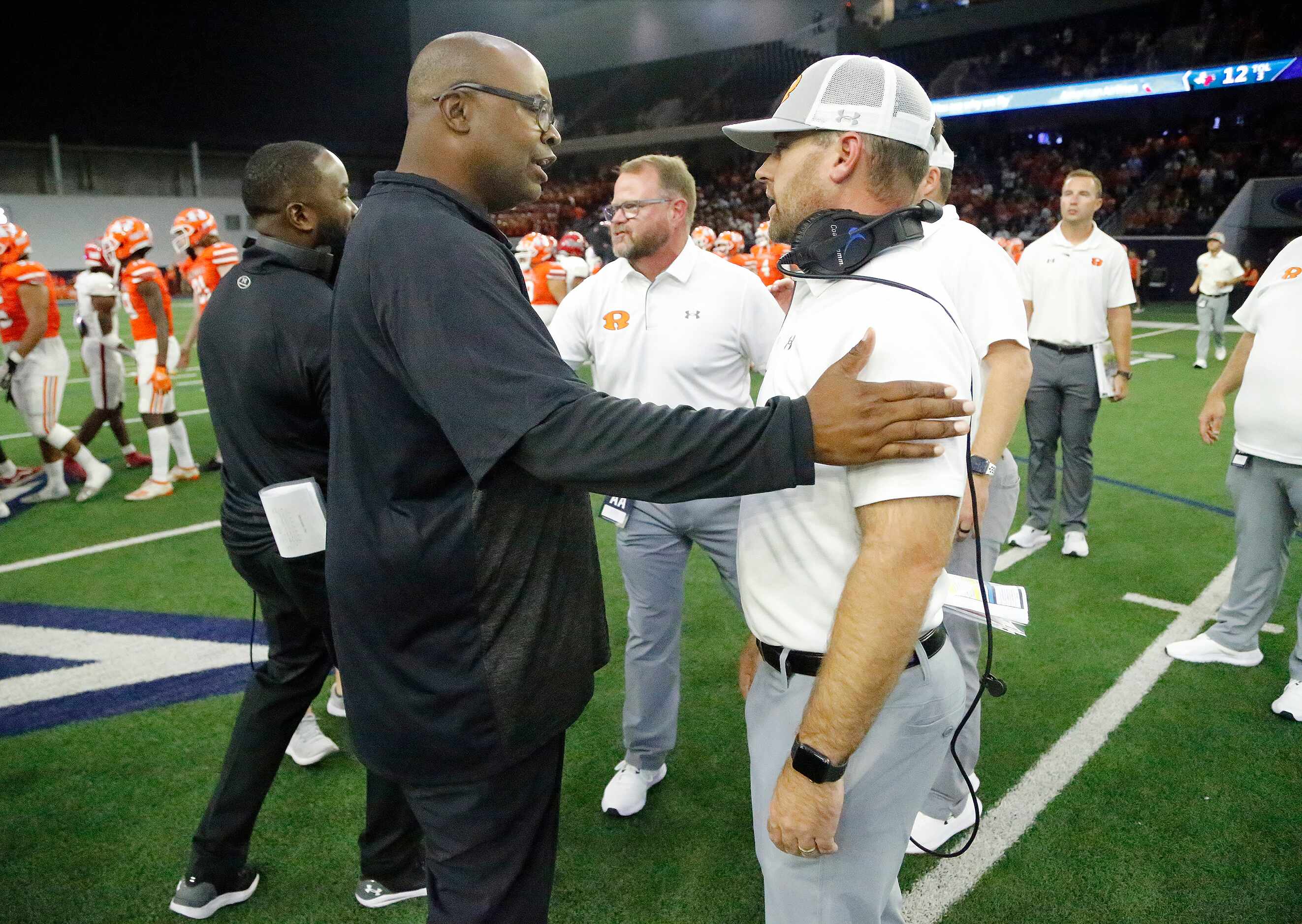 Cedar Hill head coach Carlos Lynn (left) congratulates Rockwall head coachc Trey Brooks...