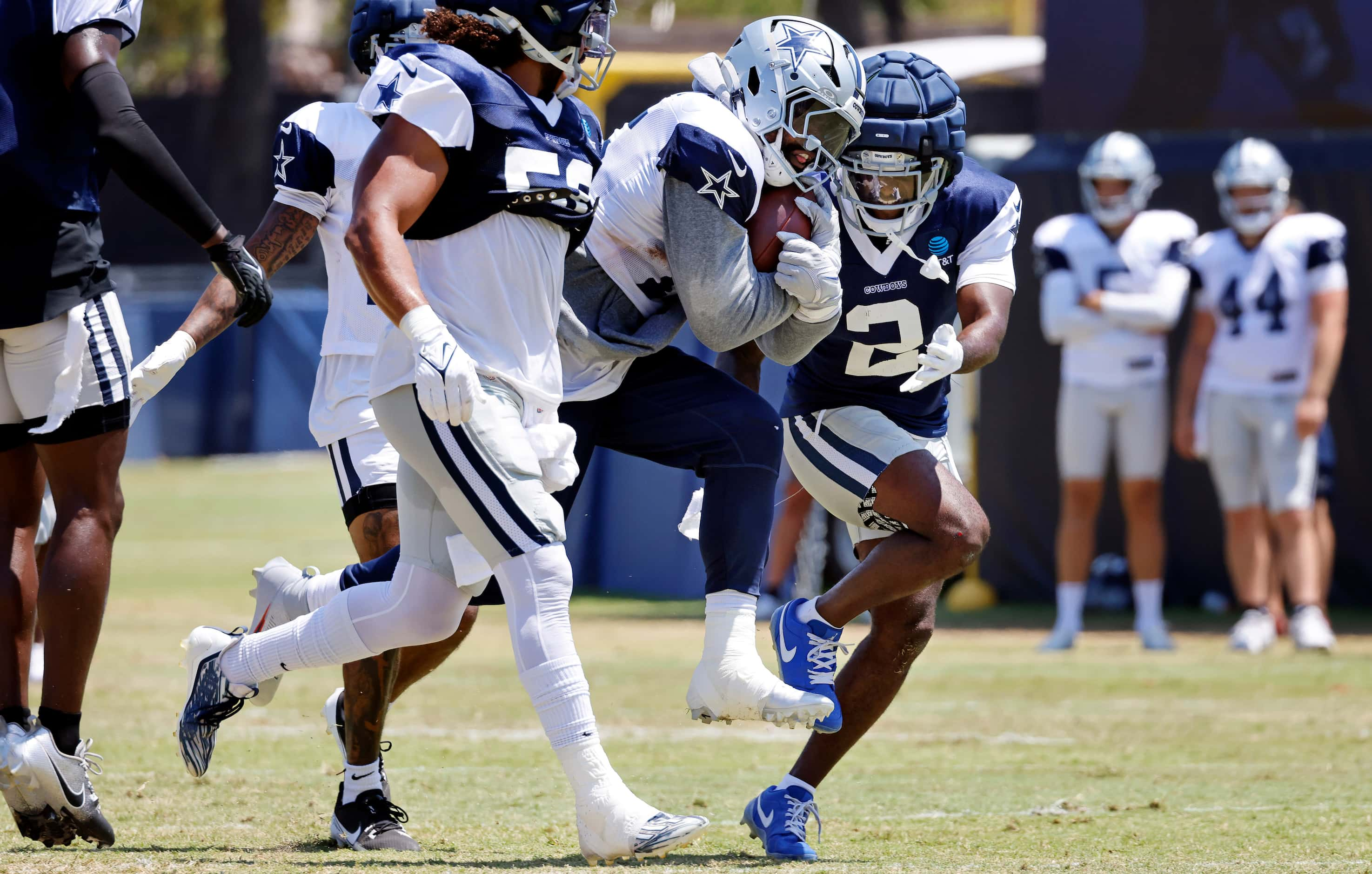 Dallas Cowboys running back Ezekiel Elliott (15) breaks through a hole as he’s hit by...