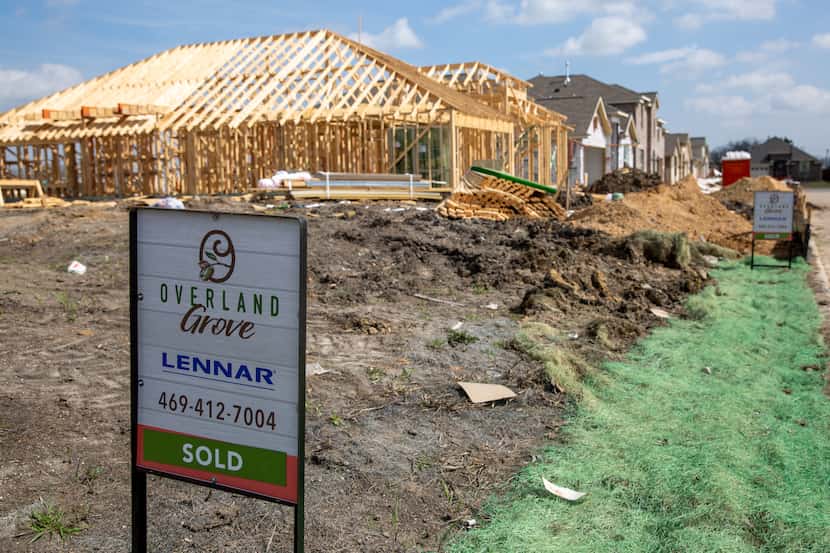 Signs line the streets in front of homes in various states of construction in the Overland...