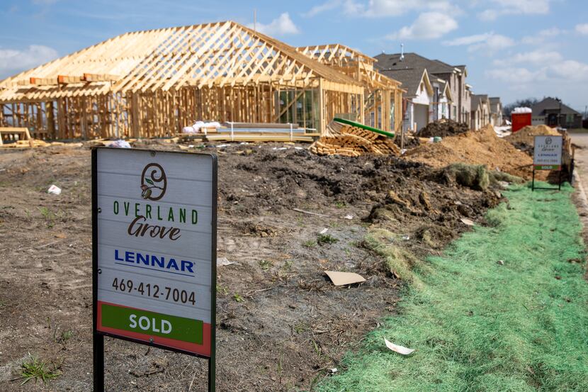 Signs line the streets in front of homes in various states of construction in the Overland...