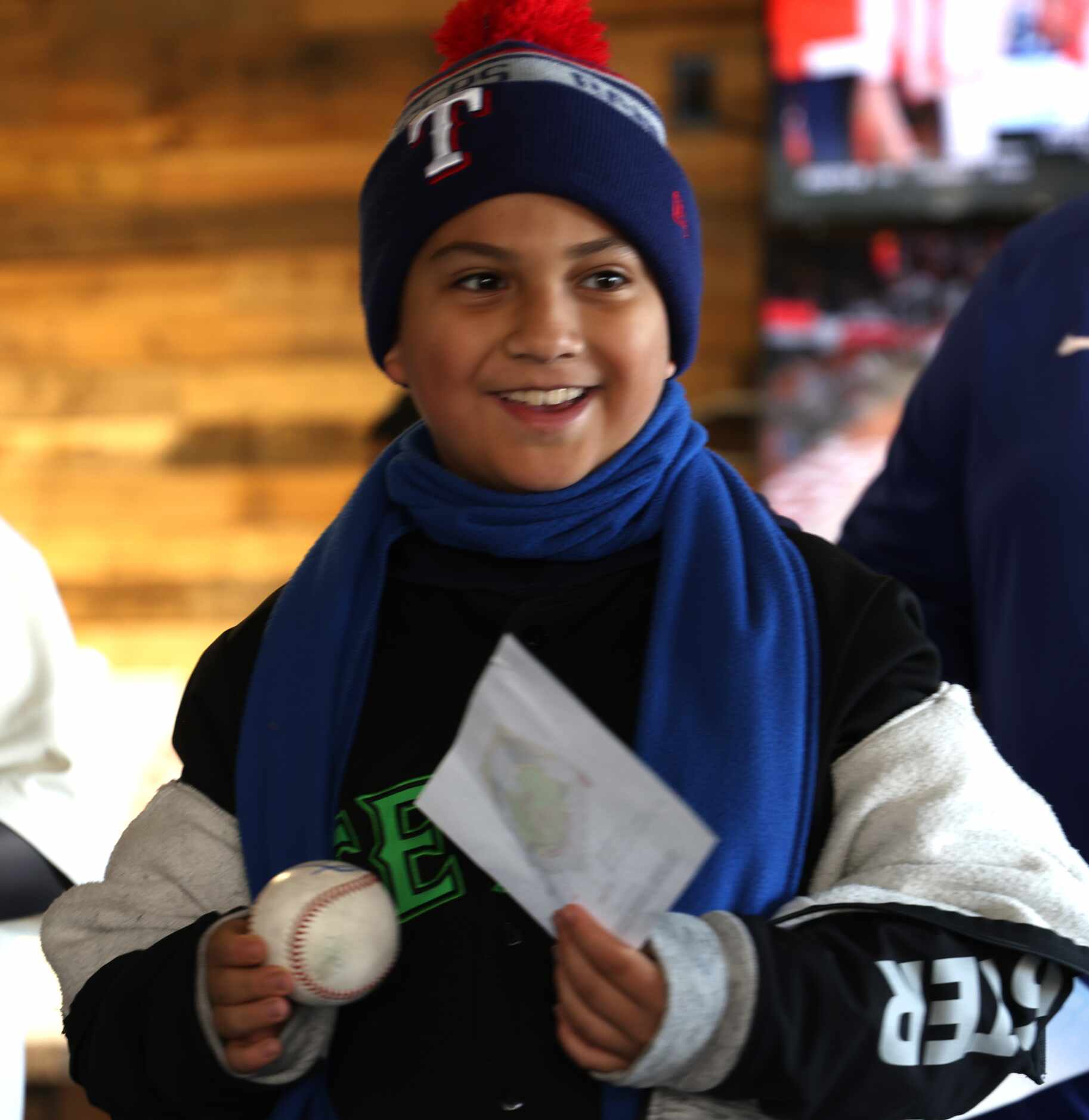 Texas Rangers fan Pablo Sosa, 9, smiles after receiving an autograph on his baseball from...