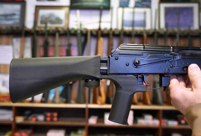 A bump stock device (left) that fits on a semi-automatic rifle to increase the firing speed,...
