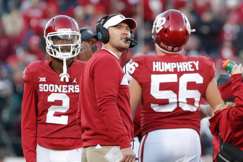 Oklahoma head coach Lincoln Riley, center, watches a replay on the video board during a time...