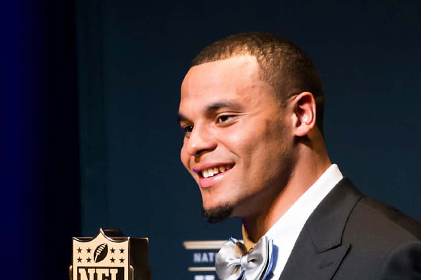 Dallas Cowboys quarterback Dak Prescott poses with the trophy after winning the AP Offensive...