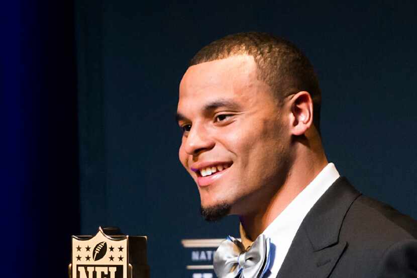 Dallas Cowboys quarterback Dak Prescott poses with the trophy after winning the AP Offensive...