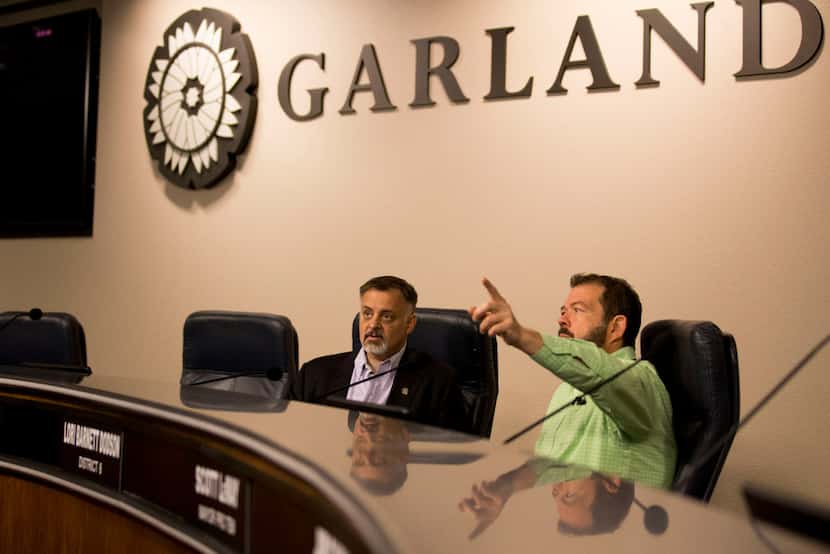 Dan Bach (right), Garland's video services manager, helps Garland City Council member Rich...
