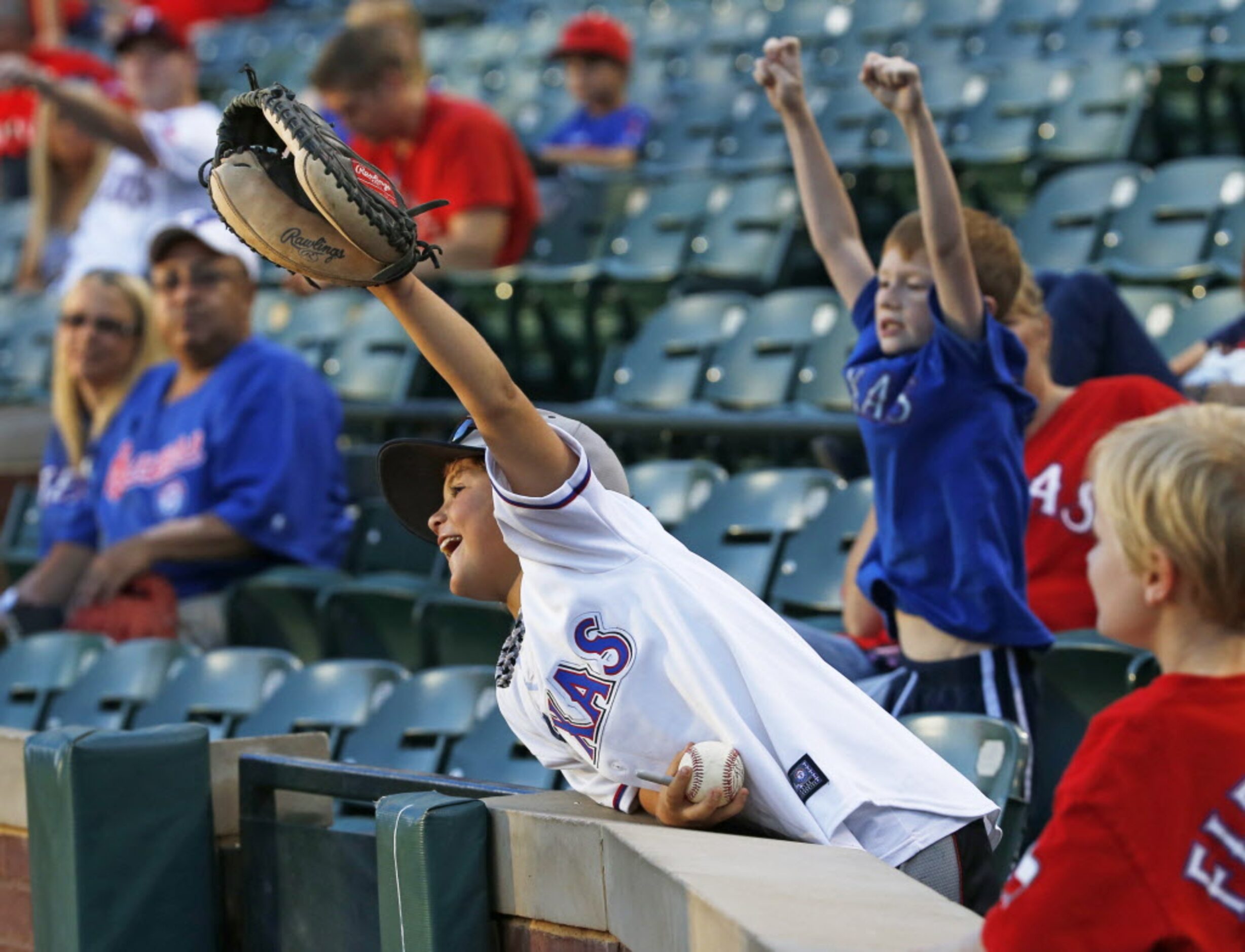 A young fan tries to get the attention of the Rangers Six-Shooters to get a tee shirt before...