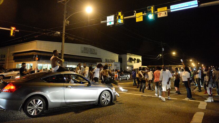 Protestors gathered Tuesday night near the Triple S Food Mart, where Alton Sterling was shot...