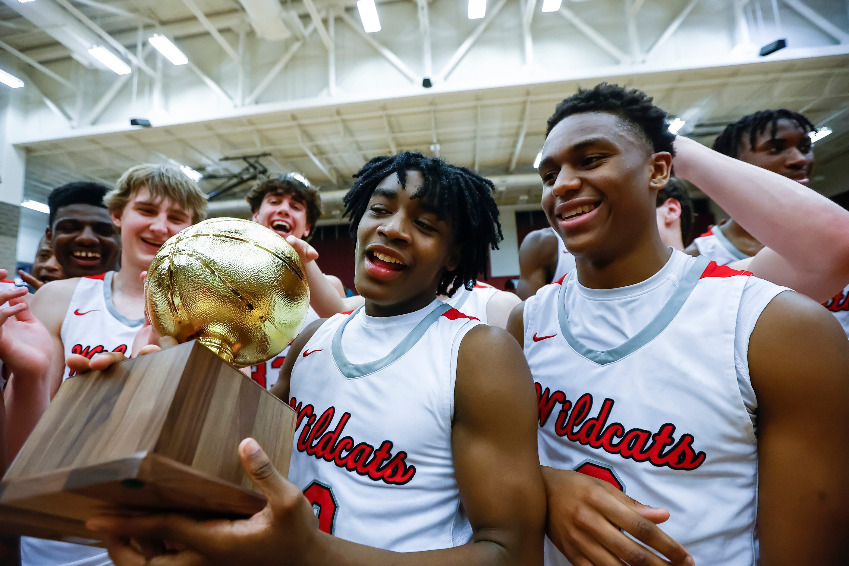 Lake Highlands junior guard Jalen Washington, holding the trophy, and senior guard Quinton...