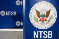 A file photo of an NTSB logo on a podium.