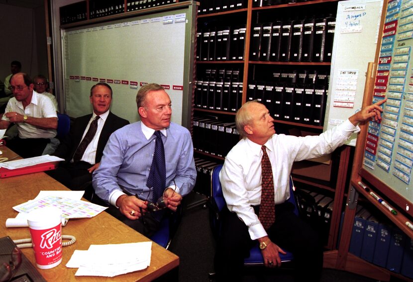 Jerry Jones (C), looks at a board  with names of players on it with Larry Lacewell (R),...