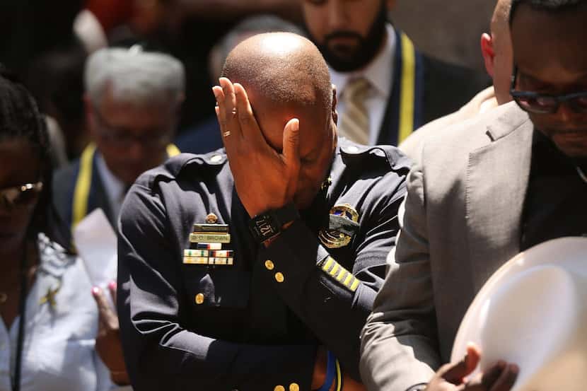 Dallas Police Chief David Brown bows his head Friday in prayer at a vigil for the deaths of...