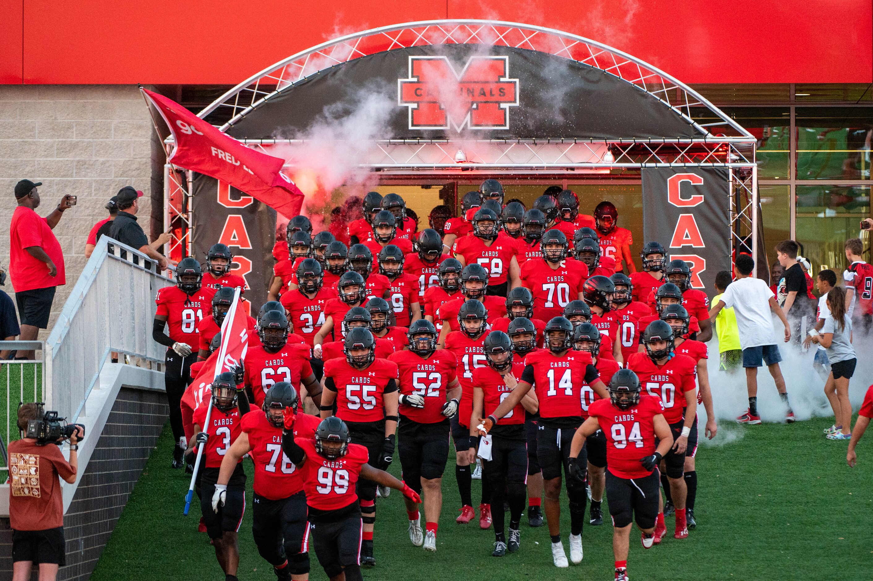  Melissa players run onto the field before a high school football game between Royse City...