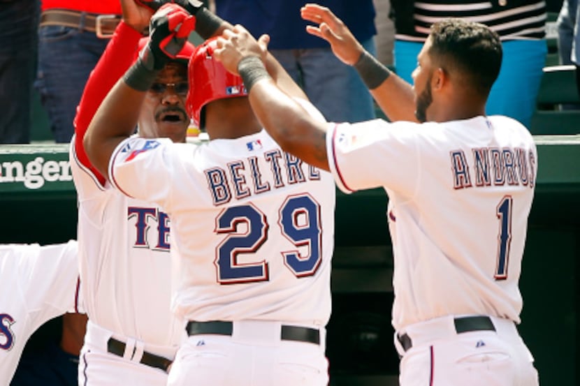 Texas Rangers third baseman Adrian Beltre (29) is congratulated at the top of the dugout by...