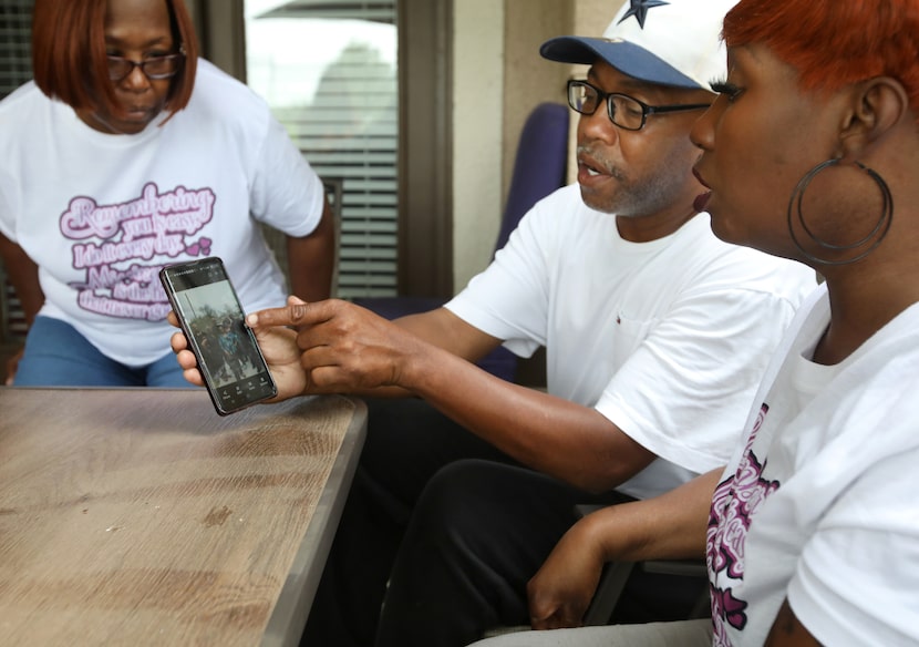 Ceola Syas (left), Anthony Syas, and Tamara Syas look at a family photograph of Joseph Syas...