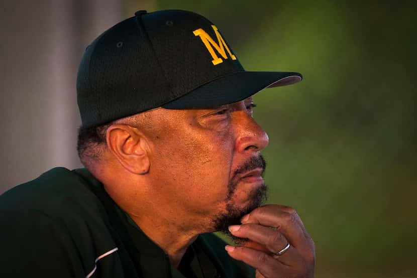 Madison head coach Joe Henry watches from the dugout during a high school baseball game...