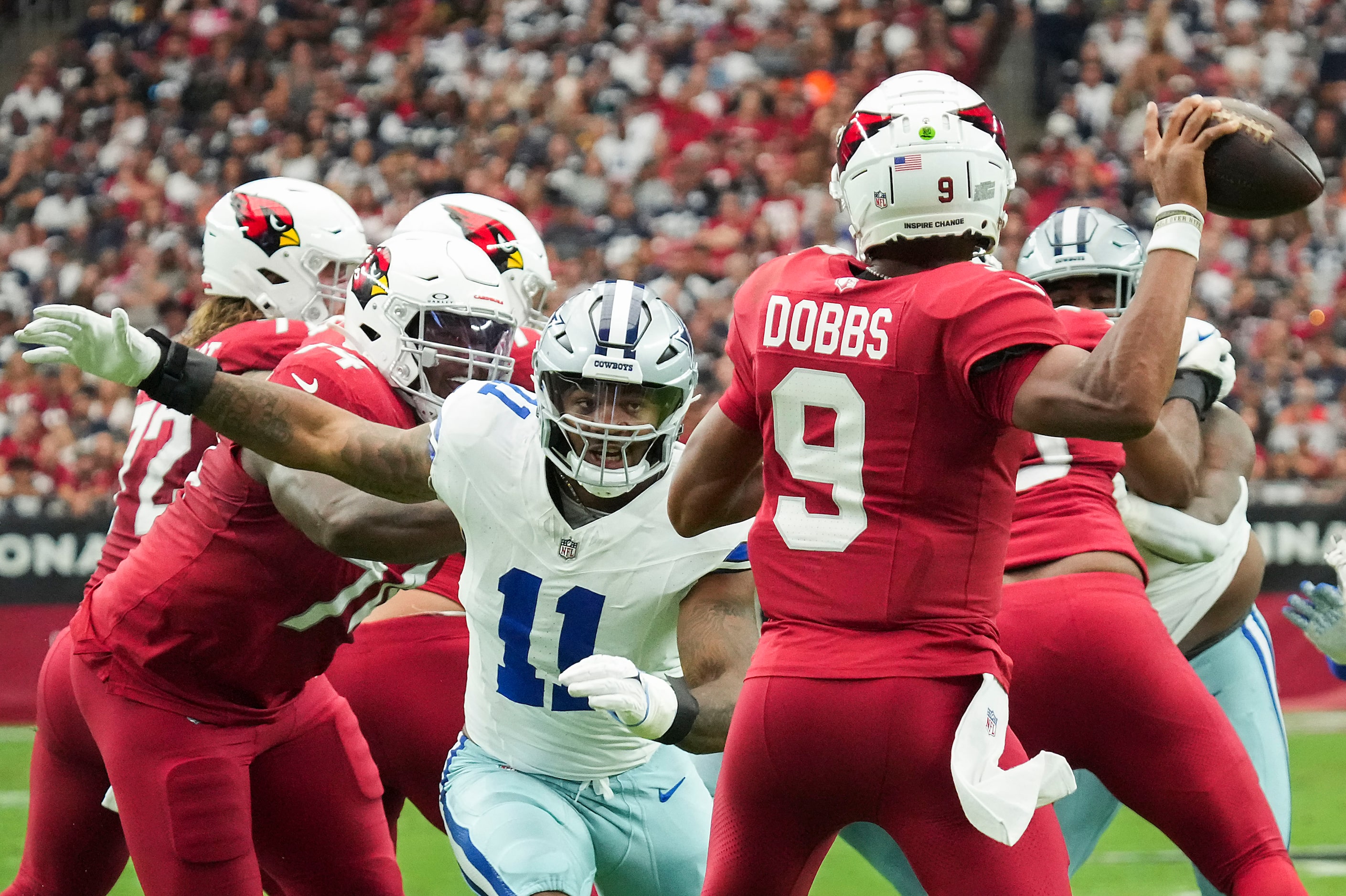 Arizona Cardinals quarterback Joshua Dobbs (9) throws a pass under pressure from Dallas...