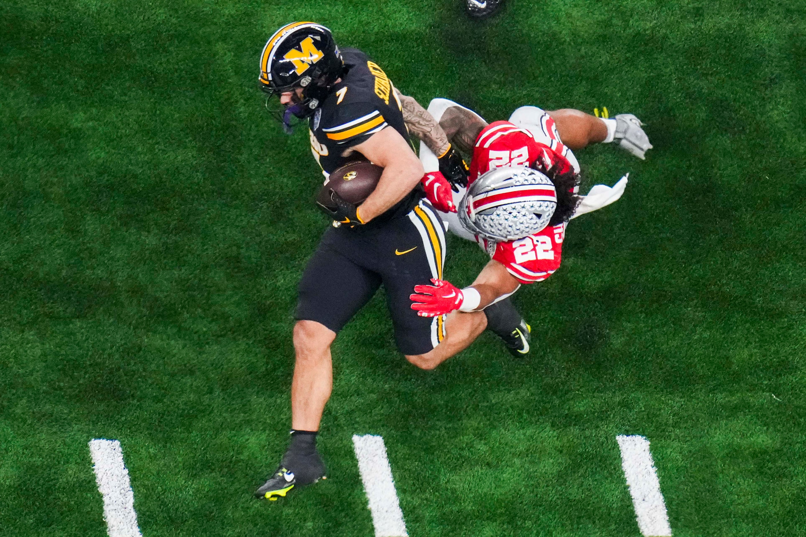 Missouri running back Cody Schrader (7) if brought down by Ohio State linebacker Steele...