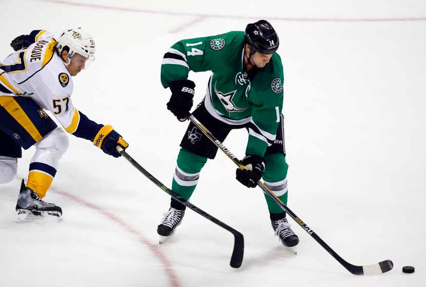 Dallas Stars' Jamie Benn (14) controls the puck as Nashville Predators' Gabriel Bourque (57)...