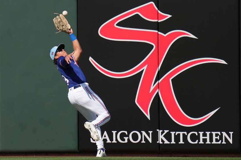 Texas Rangers outfielder Dustin Harris makes the catch on a line drive by Gavin Lux of the...