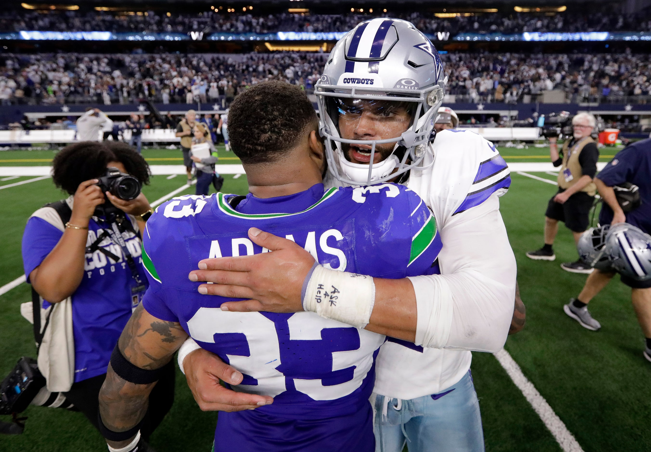 Dallas Cowboys quarterback Dak Prescott (4) receives a hug from Seattle Seahawks safety...