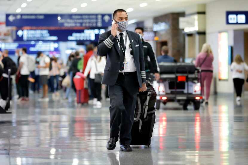 An American Airlines pilot makes his way through Terminal D at DFW Airport Friday, October...