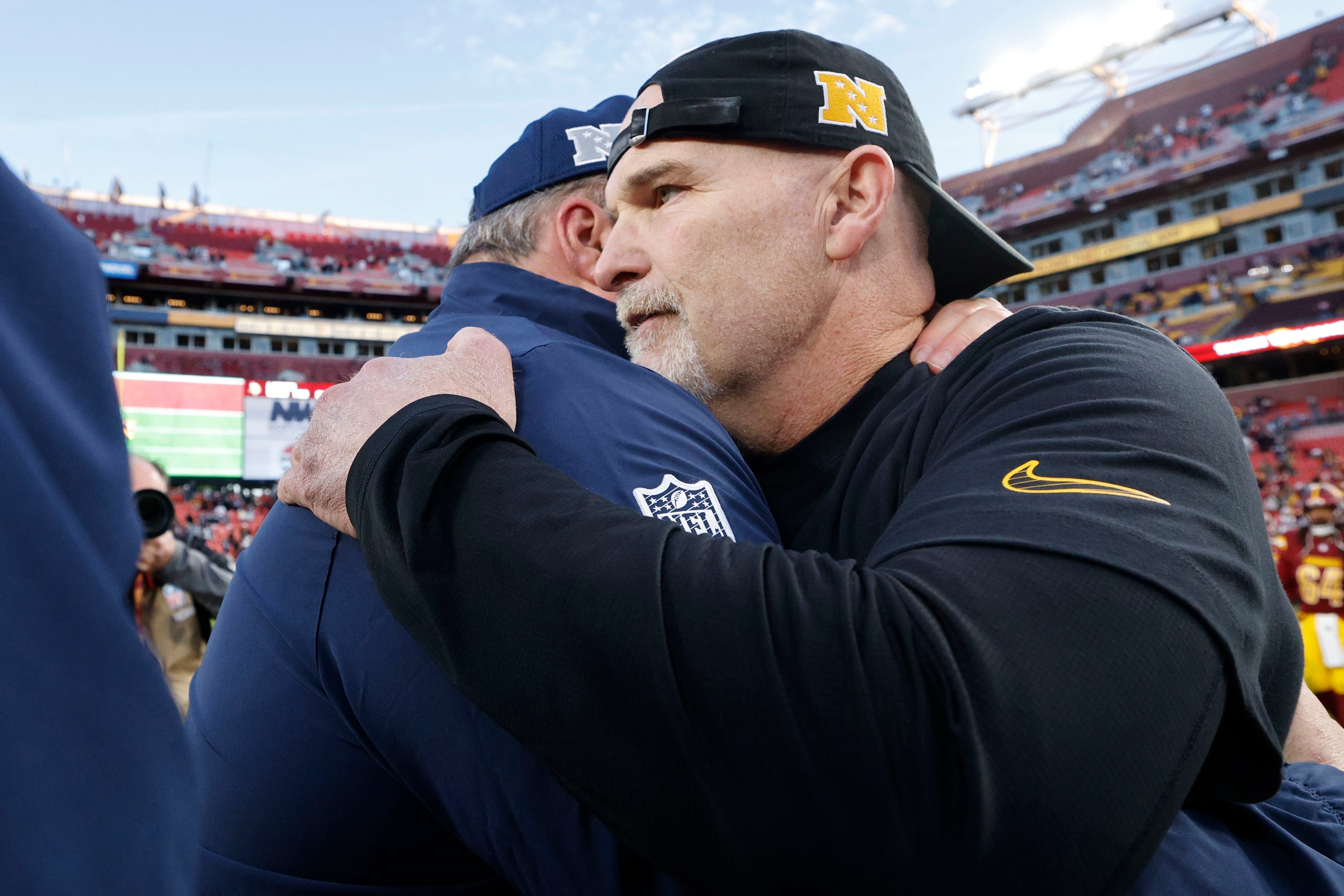 Washington Commanders head coach Dan Quinn, right, congratulates Dallas Cowboys head coach...