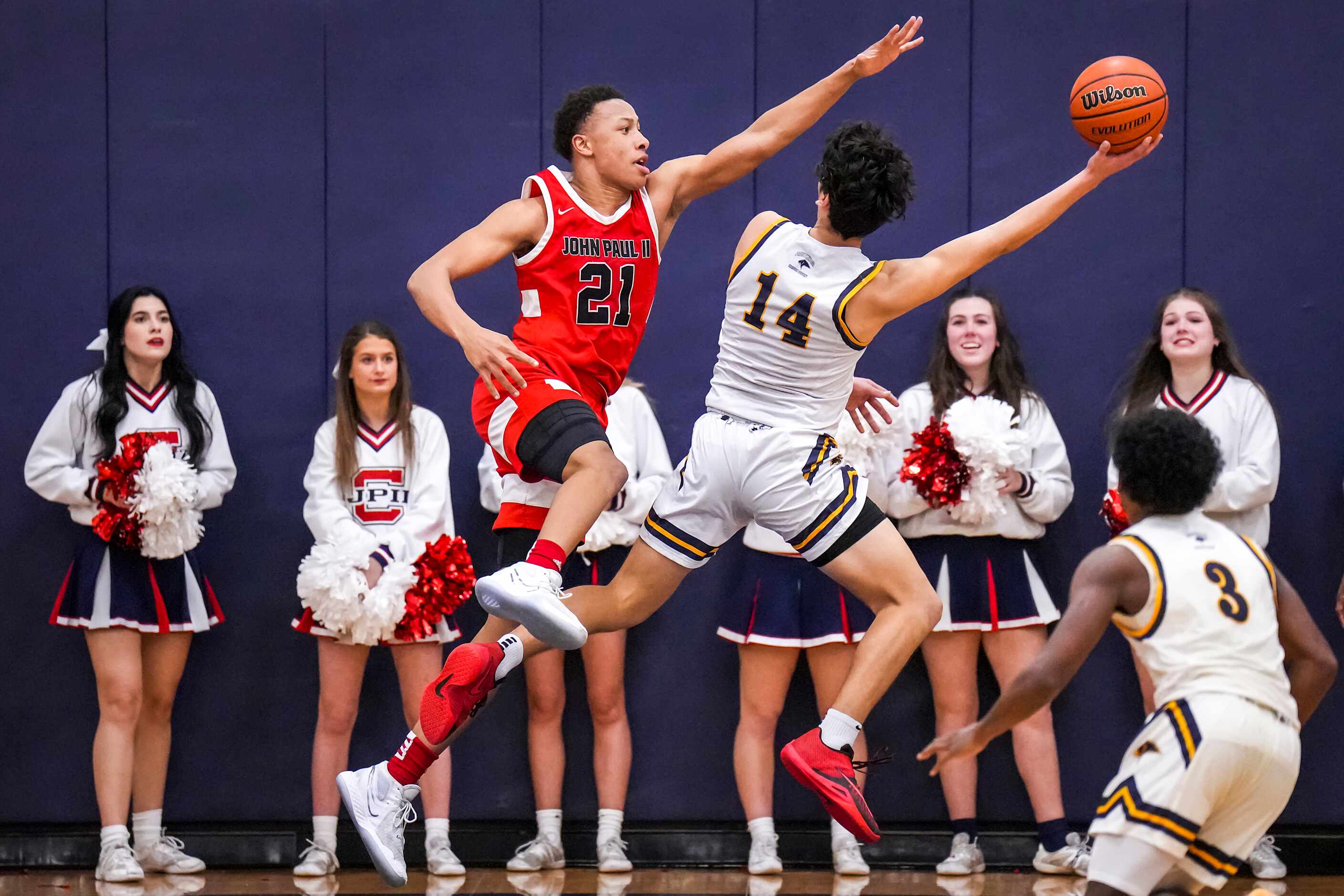 John Paul II's Gabe Warren (21) defends a shot by Prestonwood Christian's Joshua Escheik...