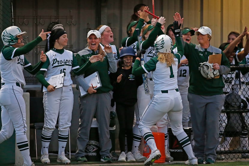 Prosper's Marina Karnes (1) is congratulated by teammates and coaches after scoring a run...