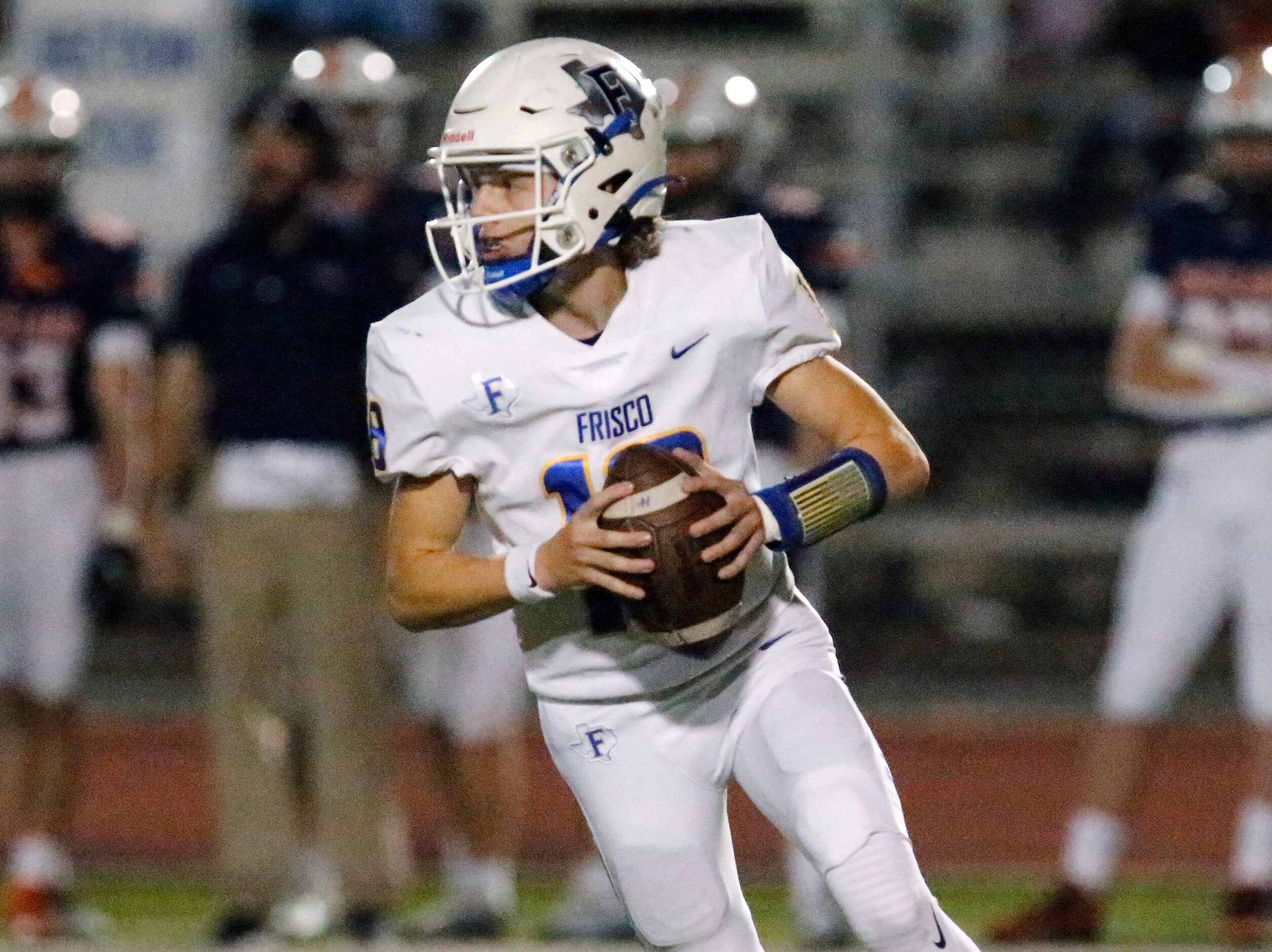 Frisco High School quarterback Camren Gibson (18) rolls out to pass during the first half as...