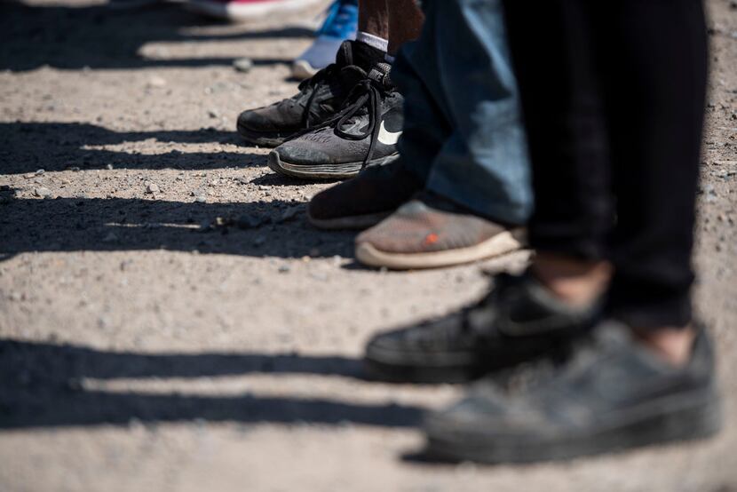 After crossing the Rio Grande from Mexico into the United States, a group of migrants are...