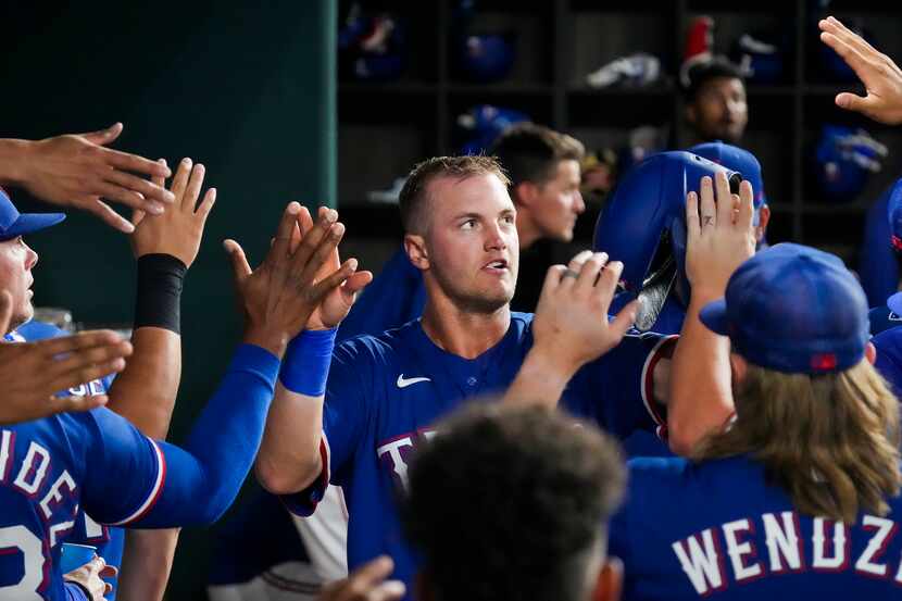 Texas Rangers third baseman Josh Jung celebrates in the dugout after scoring on a single by...