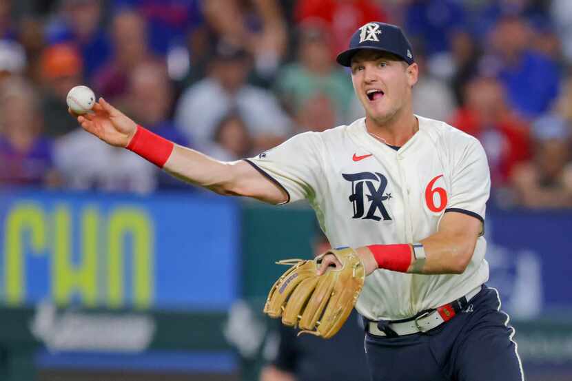 Texas Rangers third baseman Josh Jung throws to first in the eighth inning of a baseball...