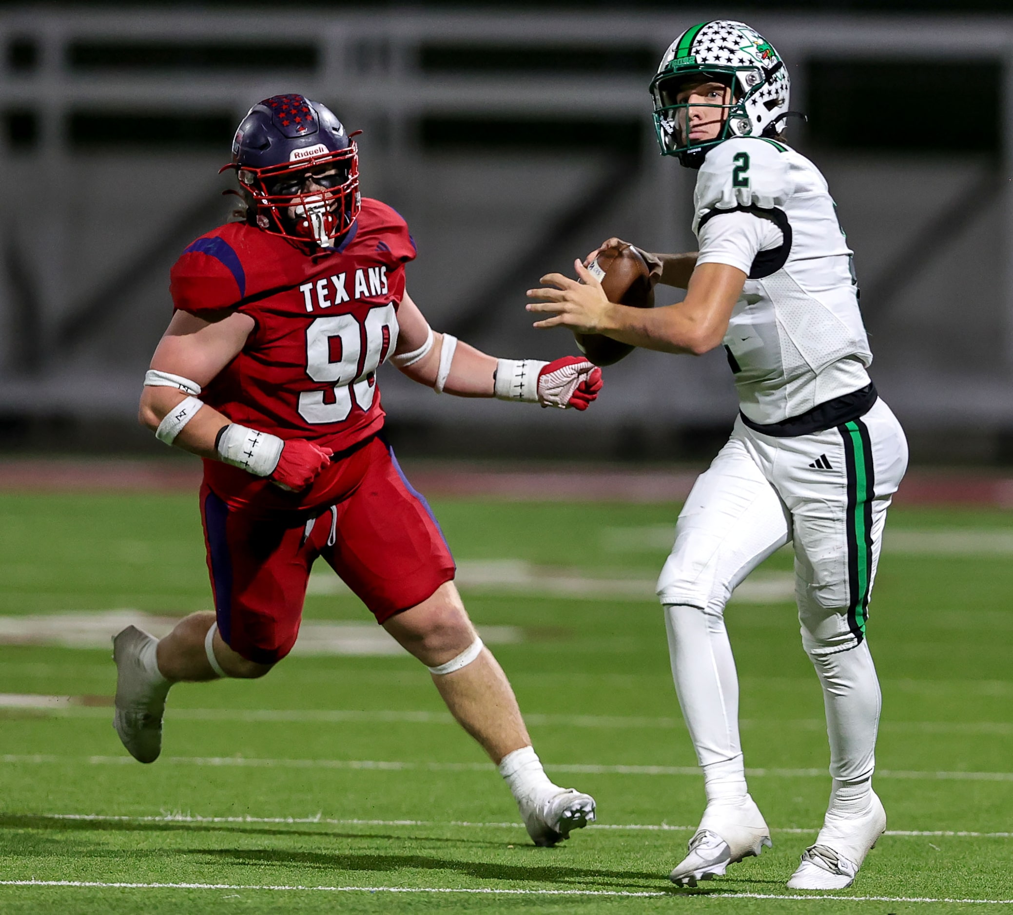 Southlake Carroll quarterback Angelo Renda (2) rolls out against Justin Northwest defensive...