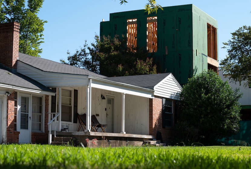 Modern homes, like the one on the right under construction in 2022, now overshadow modest...