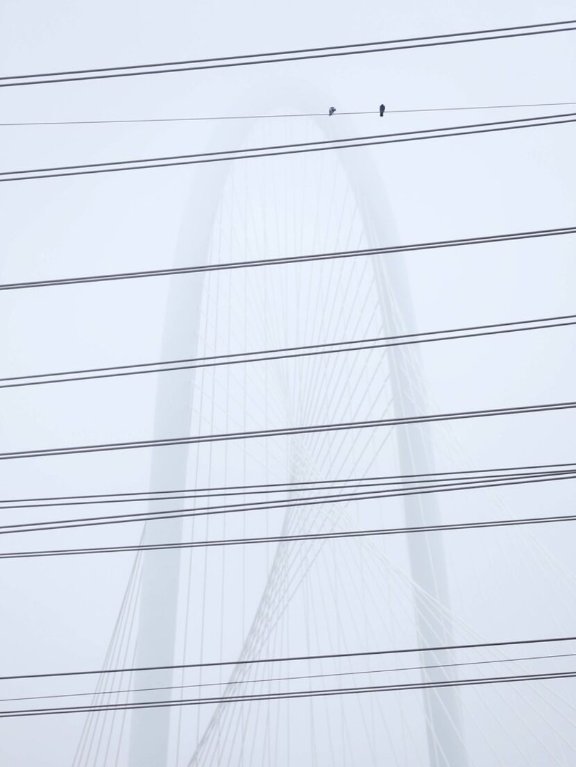 The Margaret Hunt Hill Bridge was partly obscured by fog, as seen through electric...