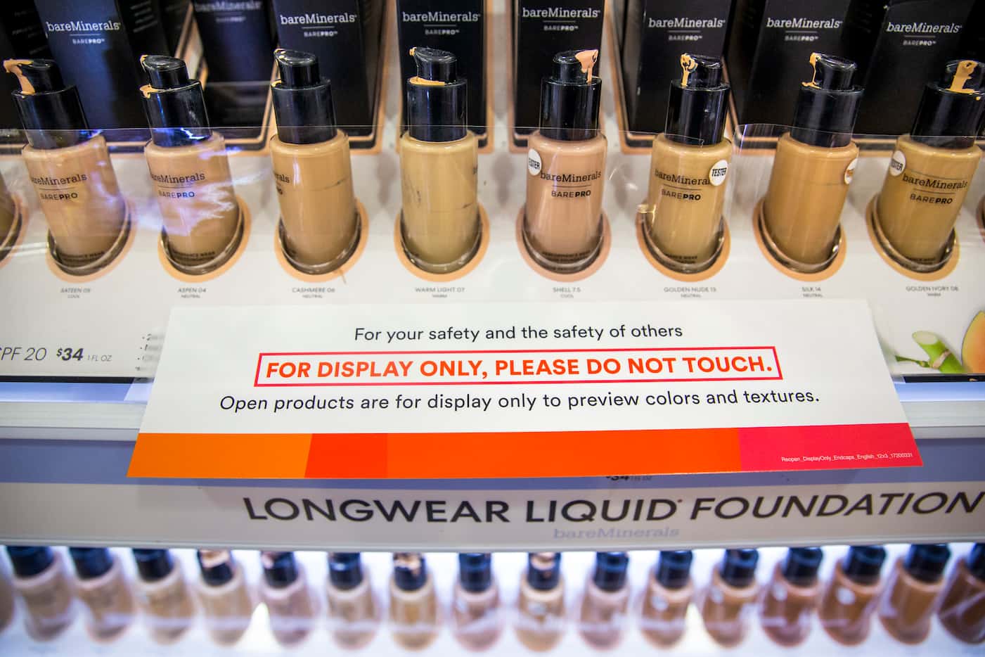 A row of sample foundation products is covered in tape to prevent customers from using them...