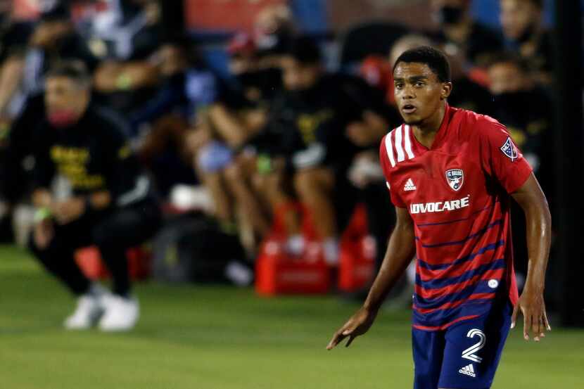 FC Dallas defender Reggie Cannon (2) stays alert in front of the team bench during first...