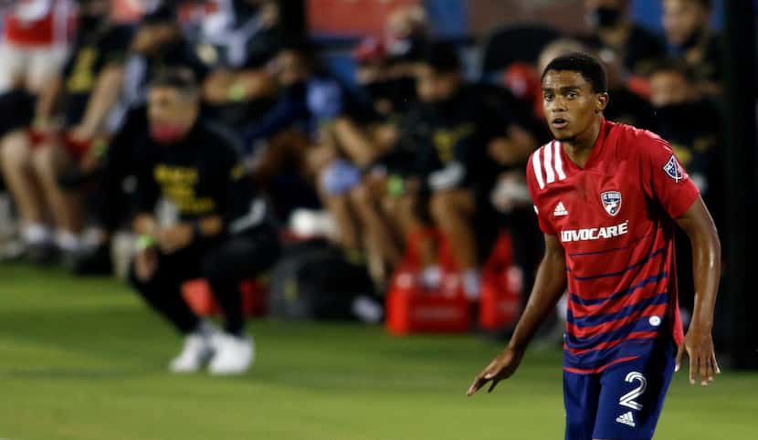 FC Dallas defender Reggie Cannon (2) stays alert in front of the team bench during first...
