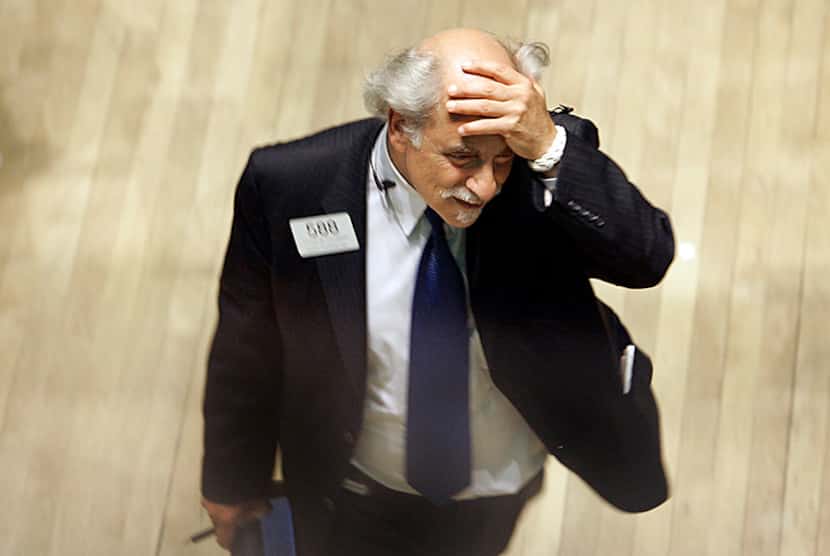  Trader Peter Tuchman rubs his head as he works or the floor of the New York Stock Exchange,...
