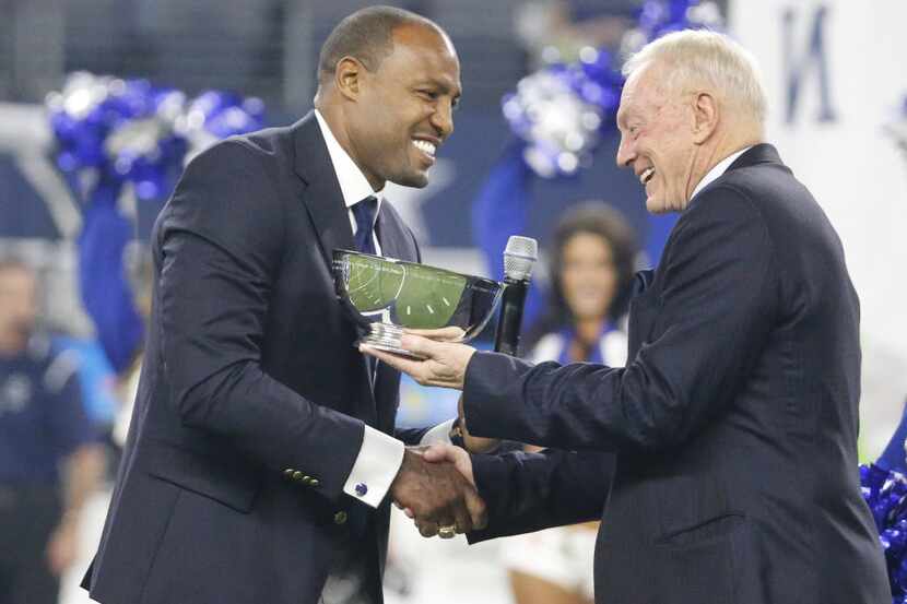 Former Cowboys safety Darren Woodson shakes hands with owner Jerry Jones during his Ring of...