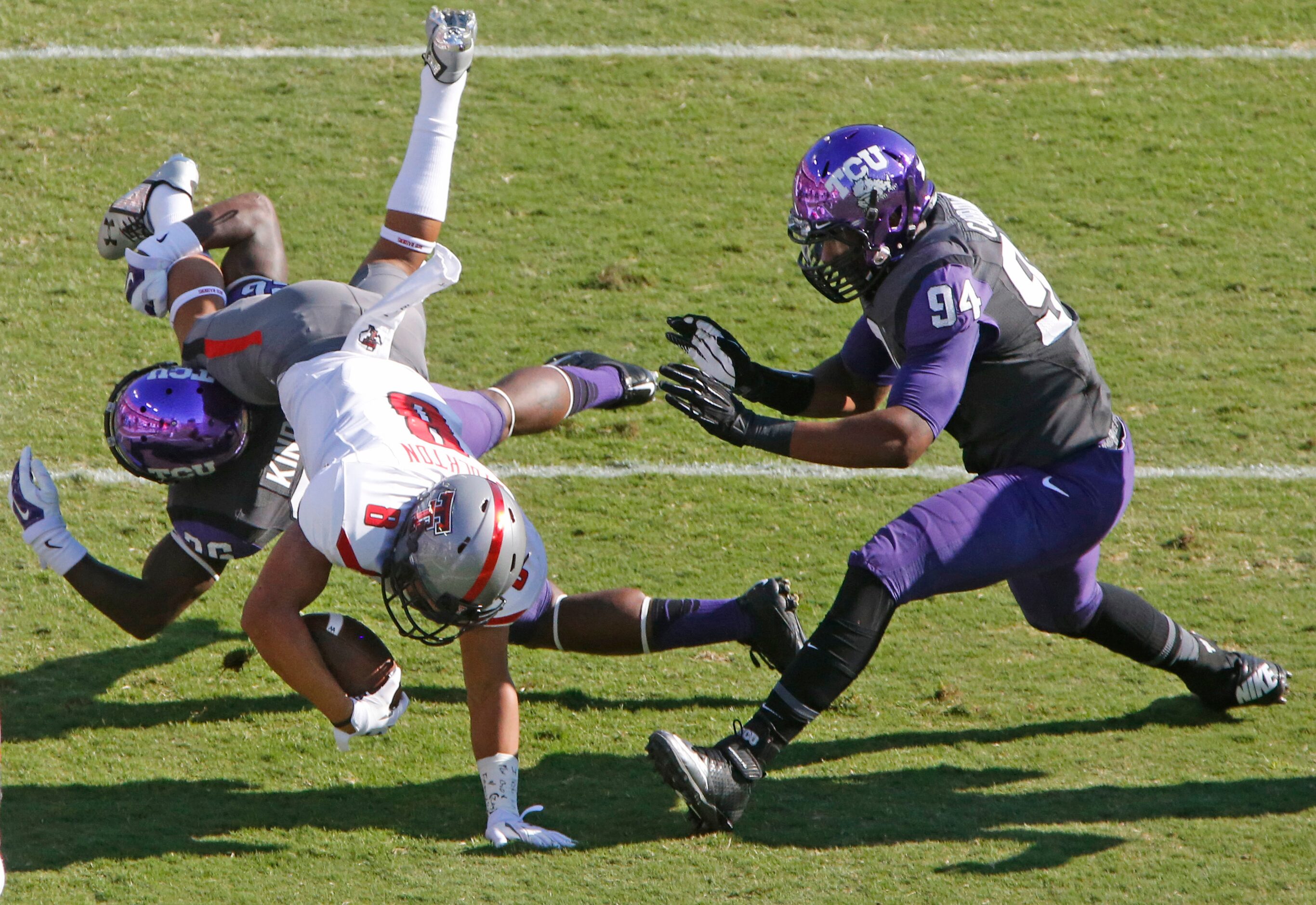 Texas Tech running back Justin Stockton (8) is tackled by TCU safety Derrick Kindred (26)...